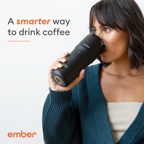 Woman drinking from a black smart coffee mug.